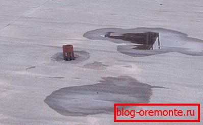 Kałuże na płaskiej powierzchni dachu