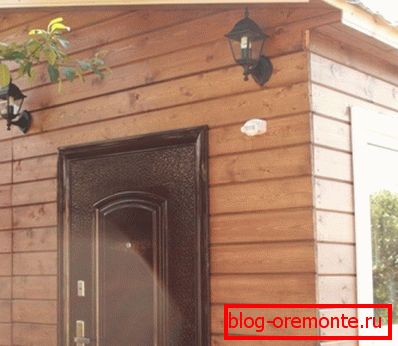 Na zdjęciu dom z zewnętrznym wykończeniem z imitacji drewna. Na zdjęciu dom z zewnętrznym wykończeniem z imitacji drewna.